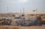 Au centre opérationnel de la division Daguet, à Olive, tentes et VAB PC camouflés sont surmontés d'antennes. Un hélicoptère Puma survole le camp. (Olive, Arabie Saoudite). 18-20 janvier 1991